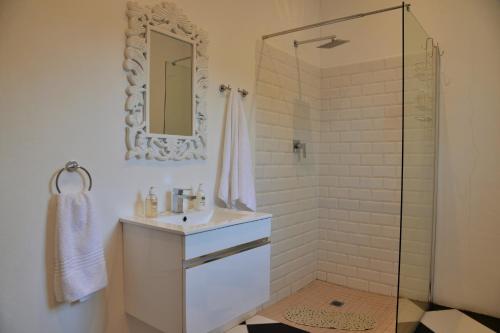 a bathroom with a sink and a shower with a mirror at Swartberg Hotel, Cork Tree Collection in Prince Albert