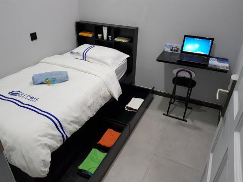 Global Residency في كوتا كينابالو: غرفة نوم مع سرير وجهاز كمبيوتر محمول على مكتب