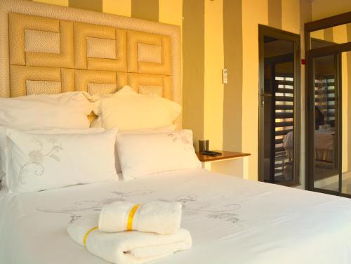 a bedroom with a bed with towels on it at SelaMod Village Guest House in Tshaneng