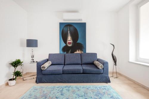 a blue couch in a living room with a painting at Divo Apartments - Spanish Steps in Rome