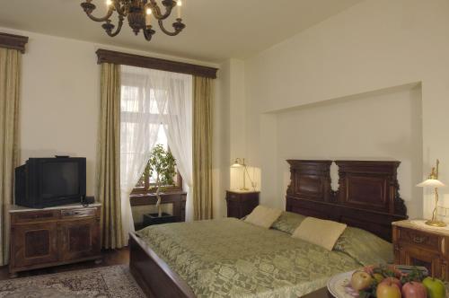 a bedroom with a bed and a television and a table at Grand Hotel Praha in Prague