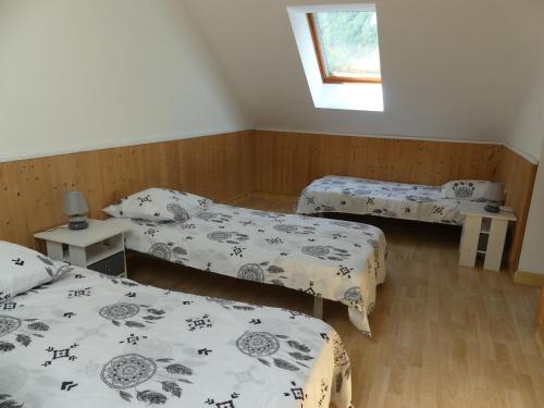 ル・ブール・ドアザンにあるchalet les myosotisのベッド3台と窓が備わる客室です。
