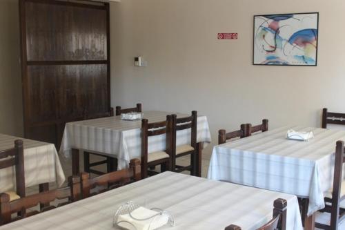 a restaurant with tables and chairs with white table cloth at Denis Hotel in Nicosia