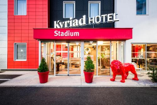 a red dog statue in front of a hotel at Kyriad Lyon Est Stadium Eurexpo Meyzieu in Meyzieu