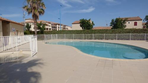 une piscine entourée d'une clôture dans l'établissement Grandes Bleues, Appartement T3 duplex, piscine, Narbonne Plage, à Narbonne-Plage