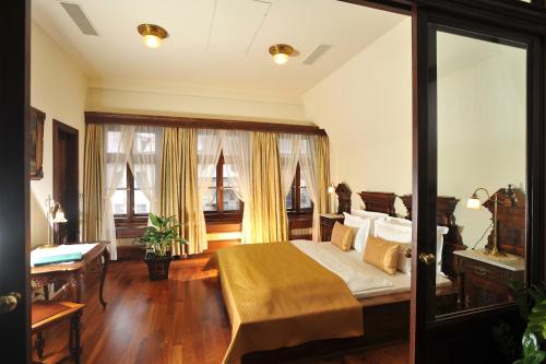 a bedroom with a bed and a large window at Grand Hotel Praha in Prague