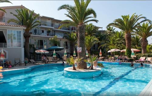 a large swimming pool with palm trees in a resort at Margarita Hotel - All Inclusive in Laganas