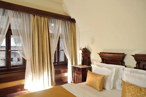 a bedroom with a bed and a window with curtains at Grand Hotel Praha in Prague