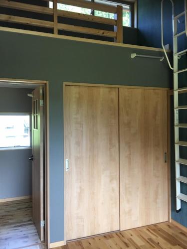 ajar door of a room with a loft at Guesthouse Kazenowa in Asahi