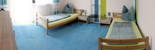 sypialnia z 2 łóżkami i niebieską podłogą w obiekcie Ferienwohnung Schröttle w mieście Munningen