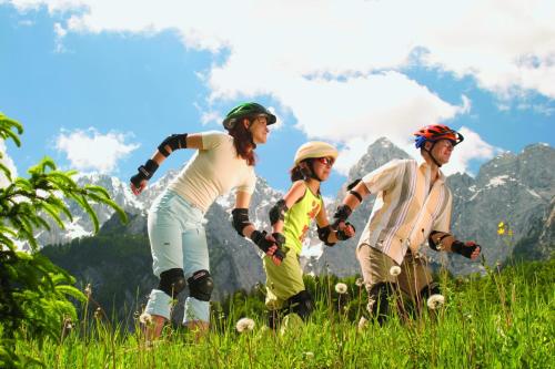 a group of people in a field with mountains in the background at Hotel Špik in Kranjska Gora