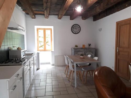 a kitchen with a table and a clock on the wall at Le Bolet in Flaujac-Gare