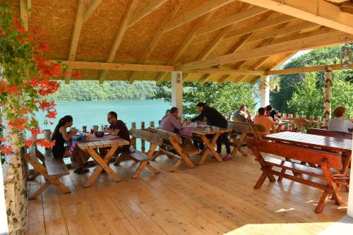 a group of people sitting at tables on a wooden deck at B&B Konak in Plužine