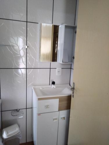 Baño blanco con lavabo y espejo en Chalé da Tranquilidade, en Gramado