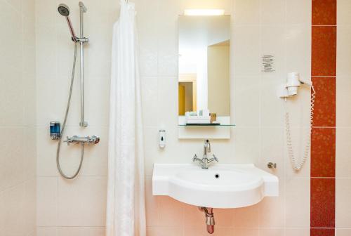 a bathroom with a sink and a shower at Meriton Old Town Garden Hotel in Tallinn