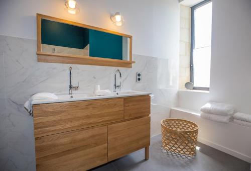 a bathroom with a sink and a mirror at L’Ostréale in La Tremblade