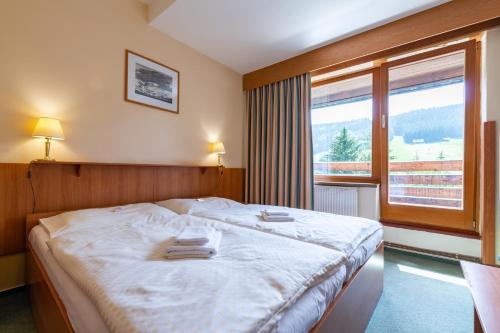 a bedroom with a bed with two towels on it at Parkhotel Harrachov in Harrachov