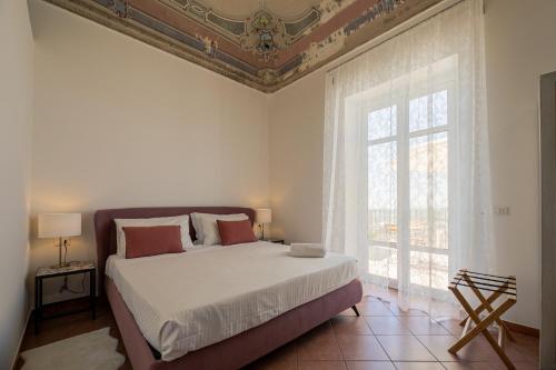 a bedroom with a bed and a window at Trigona Garden Suite in Noto
