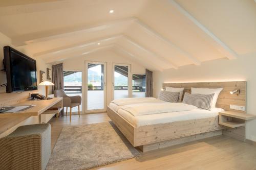 - une chambre avec un lit, un bureau et une télévision dans l'établissement Hotel garni Gerberhof ***S, à Oberstdorf