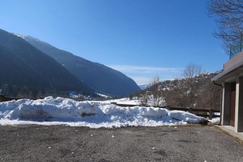 a pile of snow sitting next to a house at Grande casa di famiglia in Temù