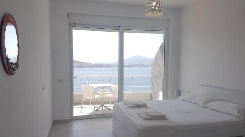 een slaapkamer met een bed en uitzicht op de oceaan bij Kristina Bellavista Rooms in Sarandë