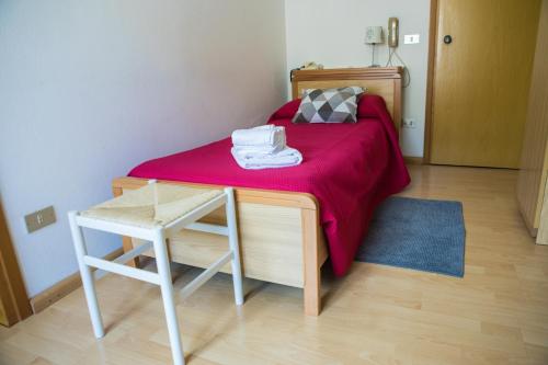 a bedroom with a bed with a red blanket on it at Hotel Park Oasi in Arta Terme