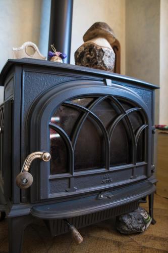 a black fireplace with a metal grate on it at Hotel Park Oasi in Arta Terme