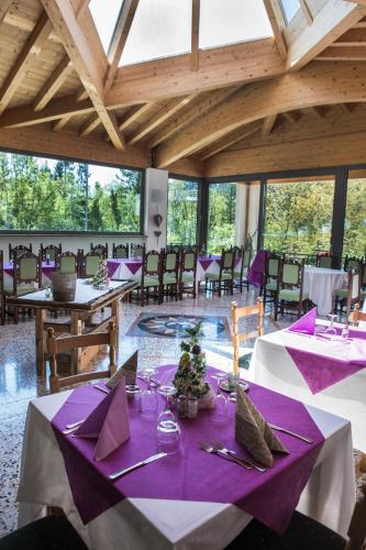 a dining room with purple and white tables and chairs at Hotel Park Oasi in Arta Terme