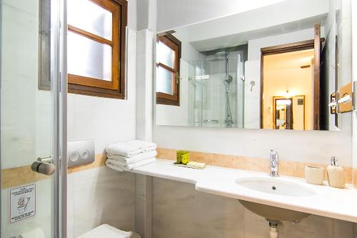 a bathroom with a sink and a mirror at ClubOrsa Chrysoula's Guest House in Skiathos