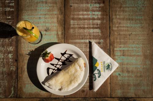 a plate of food with a piece of cake and a strawberry at Hotel Fazenda Dona Francisca in Joinville