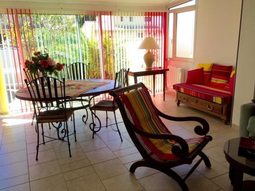 - un salon avec une table, des chaises et un canapé dans l'établissement Villa de vacances au calme proche de la mer, à La Londe-les-Maures