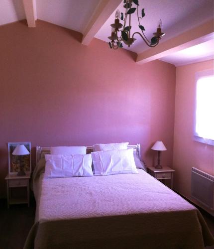 - une chambre avec un lit aux murs violets et un lustre dans l'établissement Villa de vacances au calme proche de la mer, à La Londe-les-Maures