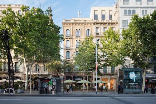 a street in a city with trees and buildings at Praktik Èssens in Barcelona