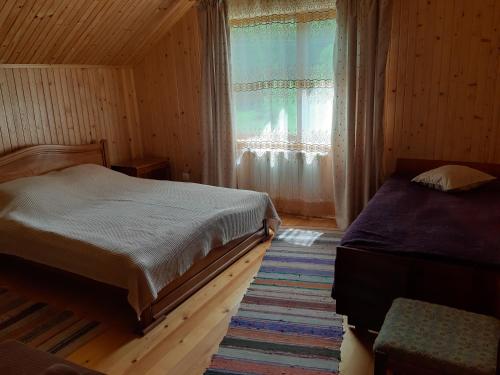 1 dormitorio con 2 camas y ventana en WoodDream, en Volovets