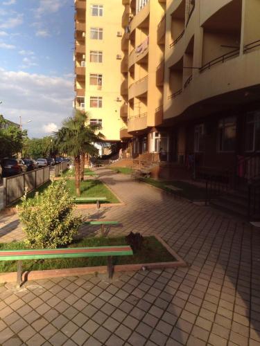 a bench sitting on a sidewalk next to a building at Kobuleti Residence Studios Apartament Maco in K'obulet'i