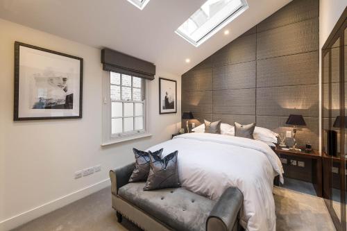 Spectacular Knightsbridge House Harrods 1 minute في لندن: غرفة نوم بسرير كبير وأريكة