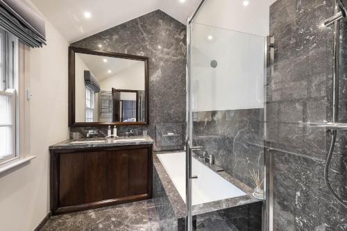 a bathroom with a shower and a sink and a mirror at Spectacular Knightsbridge House Harrods 1 minute in London