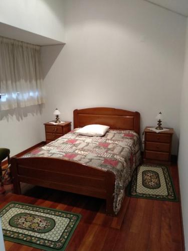 ein Schlafzimmer mit einem Bett und zwei Teppichen auf dem Boden in der Unterkunft Casa da Estivada, 313 in Vila do Conde