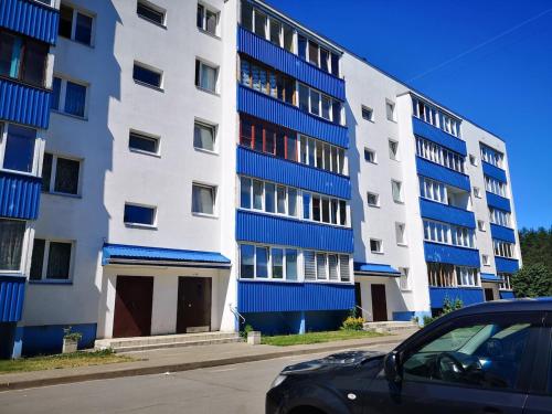 um edifício de apartamentos azul e branco com um carro estacionado em frente em Cozy Narva apartmets 10 min to city center em Narva