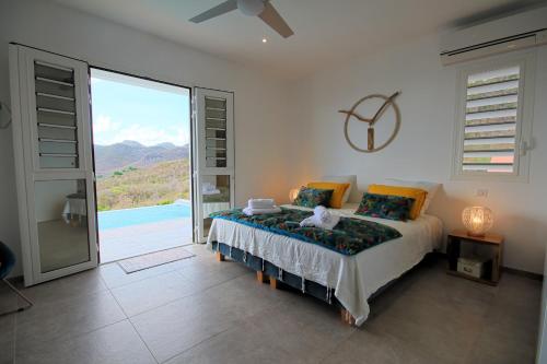レザンセス・ダルレットにあるvilla with pool and sea view (MQAA16)のベッドルーム1室(ベッド1台付)、大きなスライド式ガラスドアが備わります。