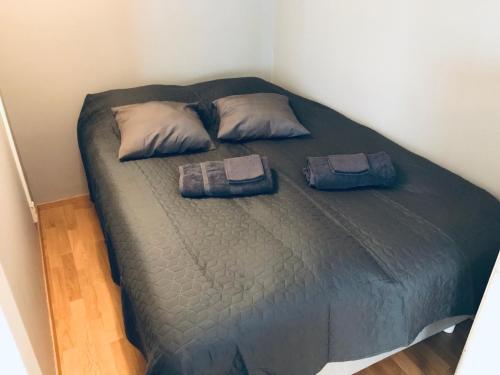 Kamppi City Apartment في هلسنكي: سرير في غرفة عليها وسادتين