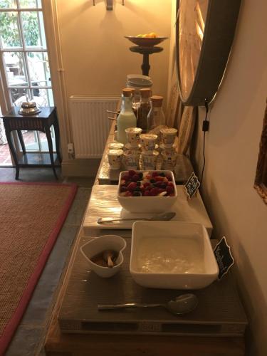 a table with bowls of food on top of it at Holly Lodge Boutique B&B in Thursford