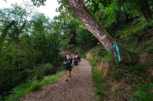 three people running on a trail in the woods at Villa Norcenni ApartHotel in Figline Valdarno