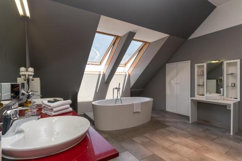 ein Badezimmer mit einer weißen Badewanne und einem Waschbecken in der Unterkunft Hotel Sandwirth in Klagenfurt am Wörthersee
