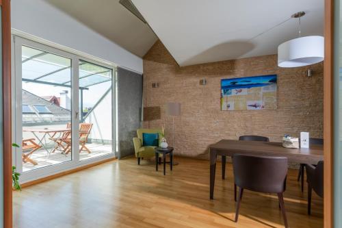 a dining room with a table and chairs and a large window at Hotel Sandwirth in Klagenfurt