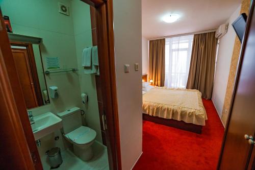 a bathroom with a bedroom with a bed and a toilet at Hotel San Terme Laktaši in Laktaši