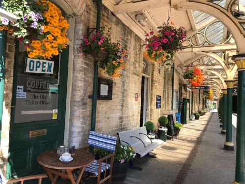 an alley with flowers hanging from the ceilings of a building at Waterside Cottage Bed and Breakfast in Knaresborough