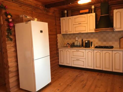 a kitchen with white cabinets and a refrigerator at Рыбацкий домик in Mayaki