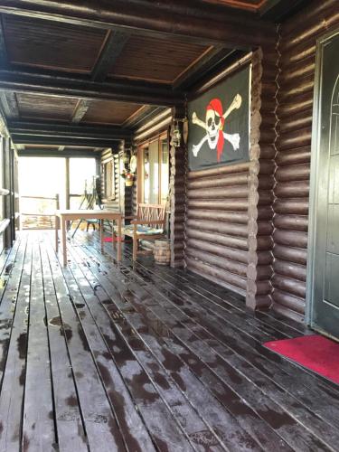 a room with a wooden floor with a pirate painting on the wall at Рыбацкий домик in Mayaki
