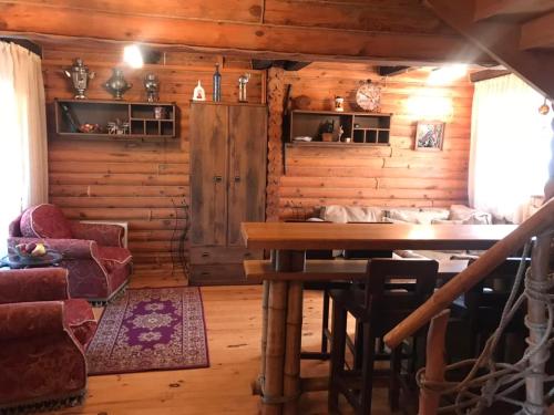 a dining room with a table in a log cabin at Рыбацкий домик in Mayaki